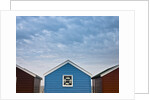 Beach huts in a row against sky by Assaf Frank